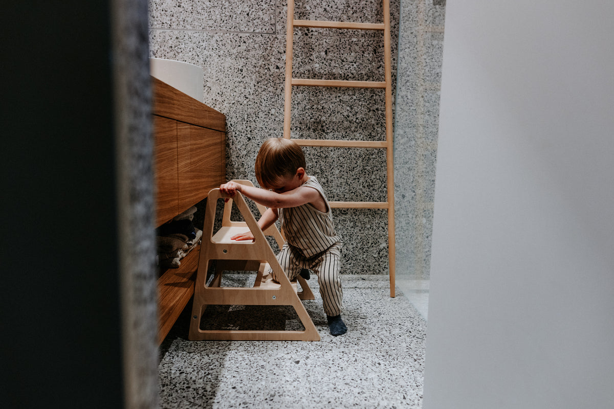 Kind nutzt den stabilen Tritthocker Step im Alltag