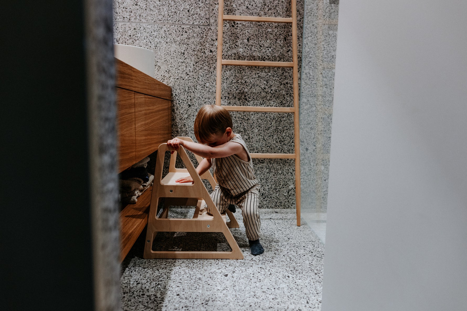 Kind nutzt den stabilen Tritthocker Step im Alltag